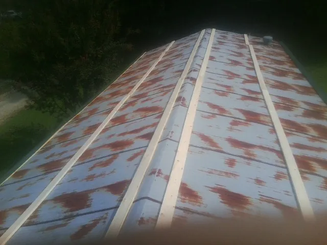 Rusted metal roof panels with new wood purlins before replacement — Storm Damage Roof Repair in Harbert by Roofing Brothers