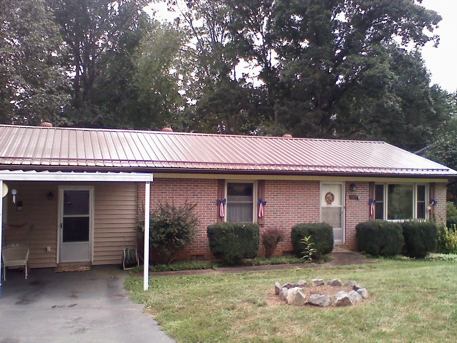 Bronze metal roof and carport on a brick ranch home — Roof Repair work by our crew in Harbert