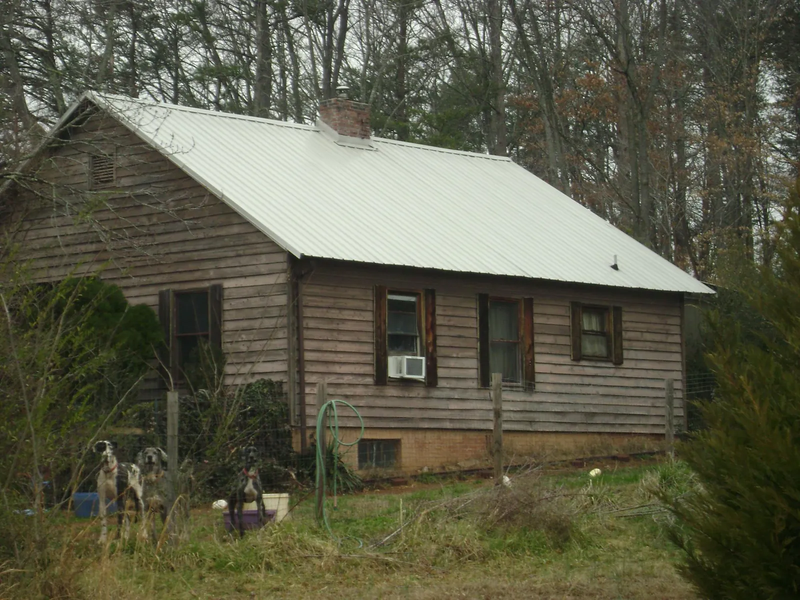 White metal roof on an old wood sided farmhouse, from a Metal Roof Installation job in Harbert